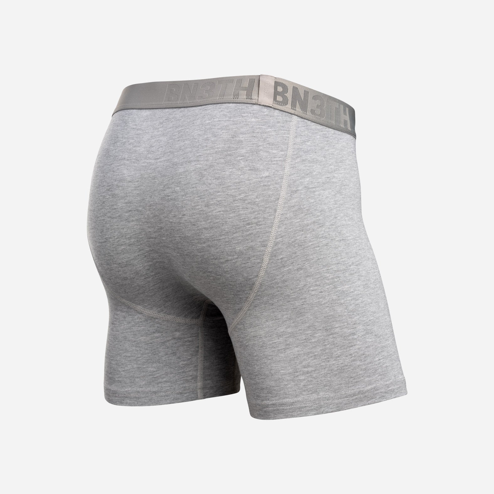 Gray heather boxer briefs shown from a rear three-quarter view, featuring a wide gray elastic waistband with the brand name 'BNEITH' printed in gray. Essentials Boxer Brief: Heather Grey